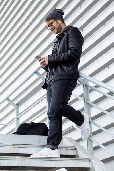 Μοντέρνα νεαρός άνδρας με το κινητό του τηλέφωνο στο δρόμο. — Φωτογραφία Αρχείου