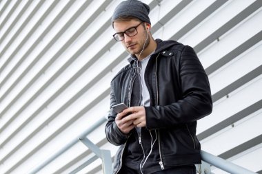 Modern genç adam sokakta cep telefonunu kullanma.