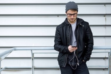 Modern genç adam sokakta cep telefonunu kullanma.