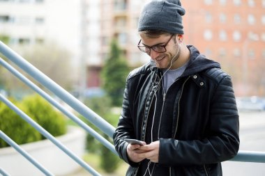 Modern genç adam sokakta cep telefonunu kullanma.