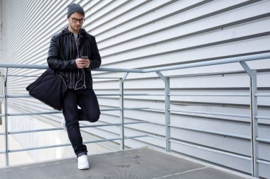 Modern genç adam sokakta cep telefonunu kullanma.