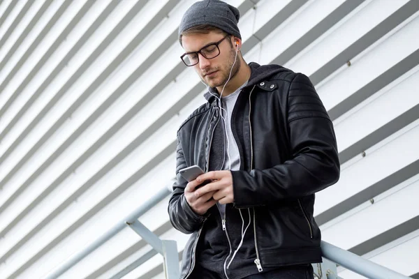 Jovem moderno usando seu telefone celular na rua . — Fotografia de Stock