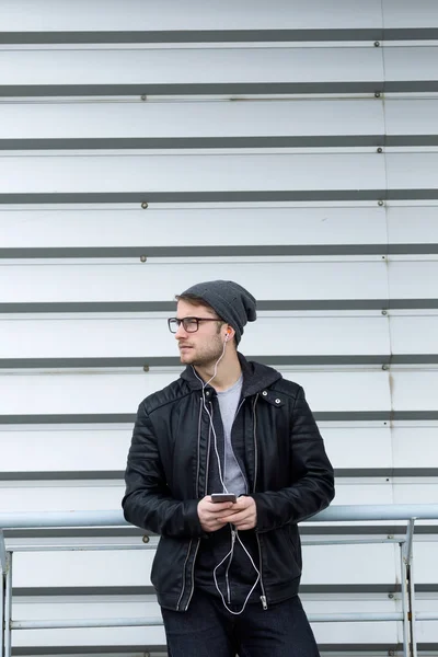 Moderne jongeman, luisteren naar muziek met mobiele telefoon in de straat. — Stockfoto