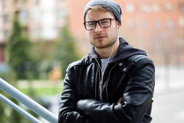 Moderne jonge man kijkend naar camera in de straat. — Stockfoto