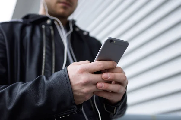 Moderna ung man använder sin mobiltelefon i gatan. — Stockfoto