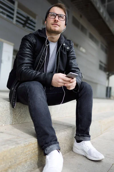 Modern fiatalember, hallgató-hoz zene-val mozgatható telefon-az utcán. — Stock Fotó
