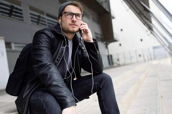 Moderne jongeman, luisteren naar muziek met koptelefoon in de straat — Stockfoto