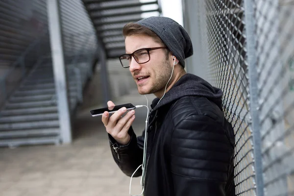 Moderne jonge man praten aan de telefoon met de handen vrij in de straat. — Stockfoto