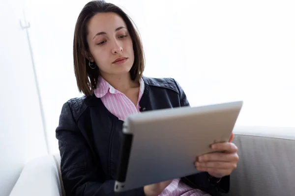 Mooie jonge vrouw met haar digitale Tablet PC in het kantoor. — Stockfoto
