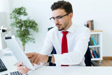 Dijital tablet ofisteki çalımakta yakışıklı genç.