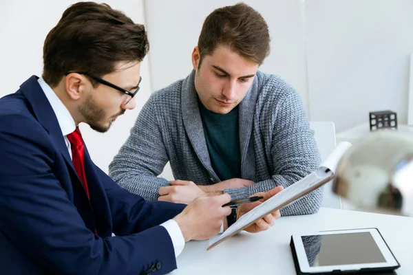 Jovem de negócios explicando termos de contrato para seu cliente em — Fotografia de Stock