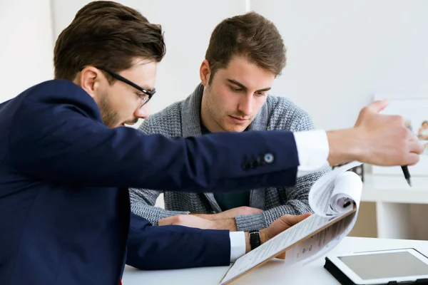 Business young man explaining terms of contract to his client in — Stock Photo, Image