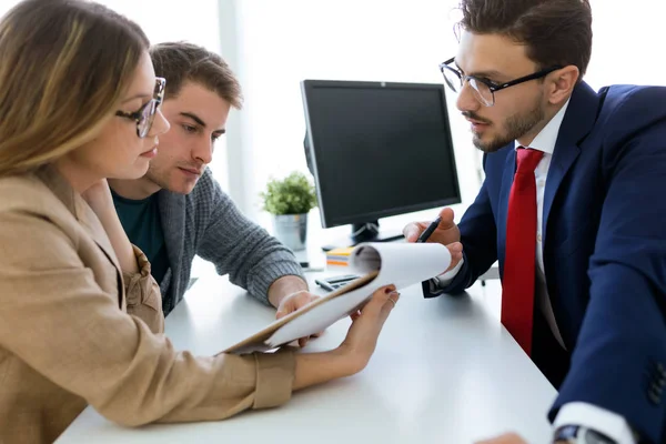 Uomo d'affari che spiega i termini del contratto ai suoi clienti nel — Foto Stock