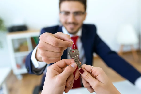 Empresário entrega as chaves da casa para um casal depois de fechar — Fotografia de Stock