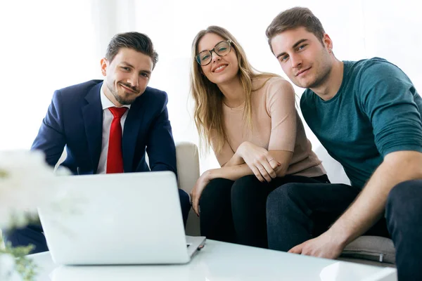 Business young man and his clients looking at camera in the offi — Stock Photo, Image