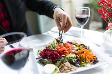 Bir plaka restoran salata hizmet veren yakışıklı genç.