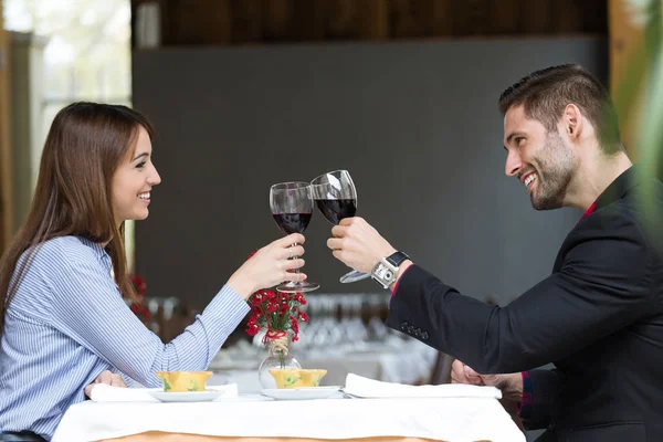 Όμορφο νεαρό ζευγάρι φρυγανίσματος κρασί γυαλιά στο εστιατόριο. — Φωτογραφία Αρχείου