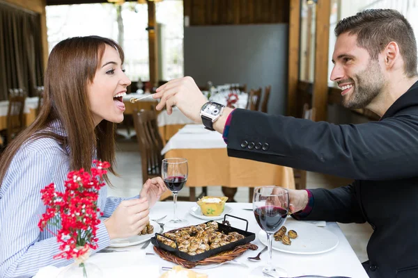 Paar eten kan van slakken in het restaurant. — Stockfoto