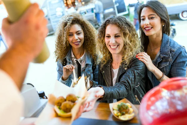 Tres hermosas mujeres jóvenes visitando comer mercado en la calle . — Foto de Stock