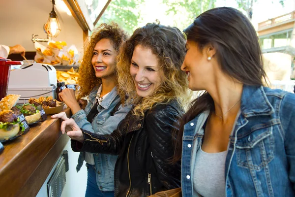 Three beautiful young women visiting eat market in the street. — Stock Photo, Image
