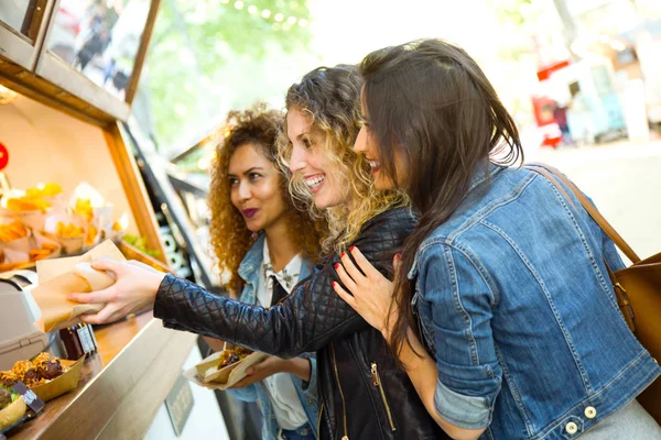 Tres hermosas mujeres jóvenes visitando comer mercado en la calle . —  Fotos de Stock