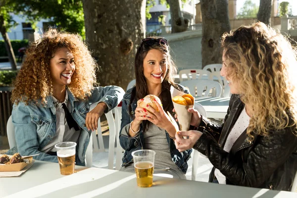 Tre belle giovani donne in visita mangiano mercato in strada . — Foto Stock