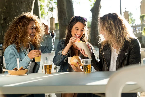 Drei schöne junge Frauen besuchen Imbissmarkt auf der Straße. — Stockfoto