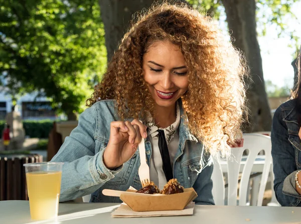 Bella giovane donna che mangia in strada . — Foto Stock