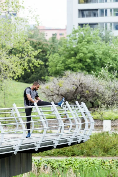 Fit and sporty young man doing stretching in the city. — Stock Photo, Image