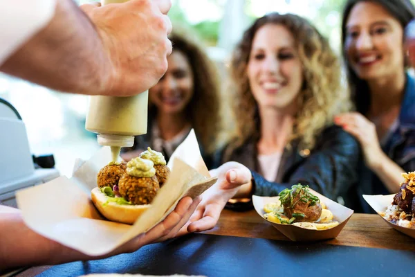 Tre belle giovani donne che comprano polpette su un camion di cibo . — Foto Stock