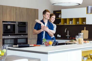 Güzel genç çift evde mutfakta eğleniyor.