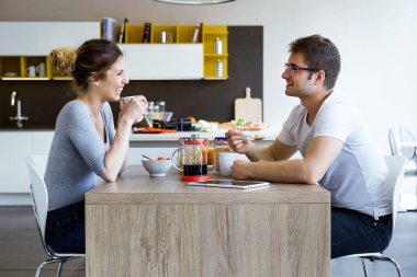 Güzel genç çift evde mutfakta kahvaltı keyfi