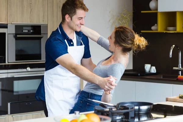 Belo jovem casal se divertindo na cozinha em casa . — Fotografia de Stock