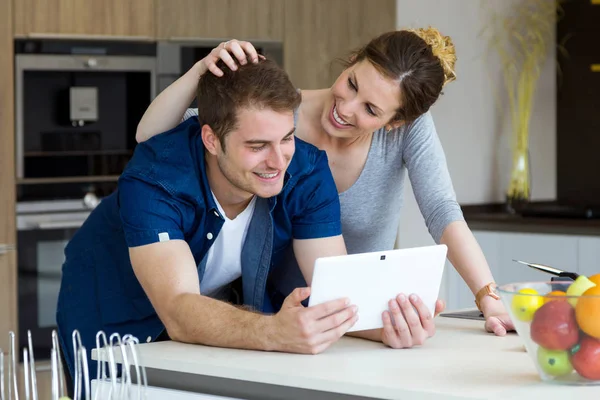 Mooie jonge paar gebruiken ze digitale tablet in de keuken — Stockfoto