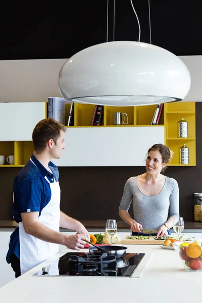 Feliz casal jovem cozinhar juntos na cozinha em casa. — Fotografia de Stock