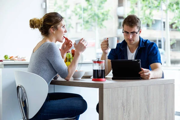 Hermosa pareja joven disfrutando del desayuno en la cocina en casa — Foto de Stock