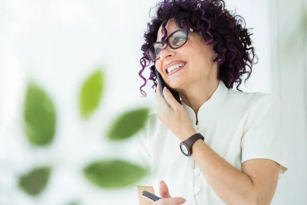 Bella donna d'affari che lavora con il suo telefono cellulare in ufficio . — Foto Stock