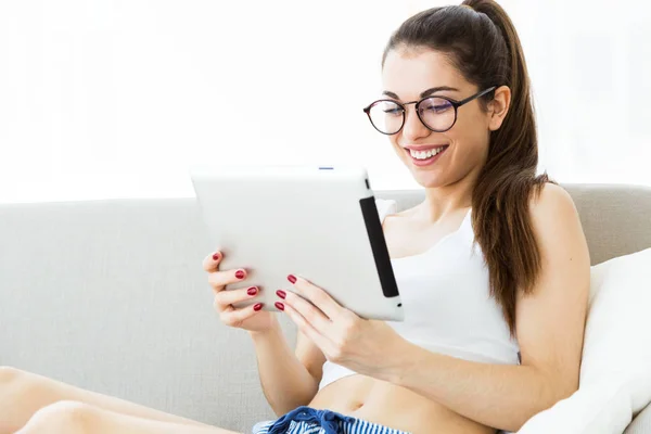Krásná mladá žena doma pomocí její digitální tabletu. — Stock fotografie