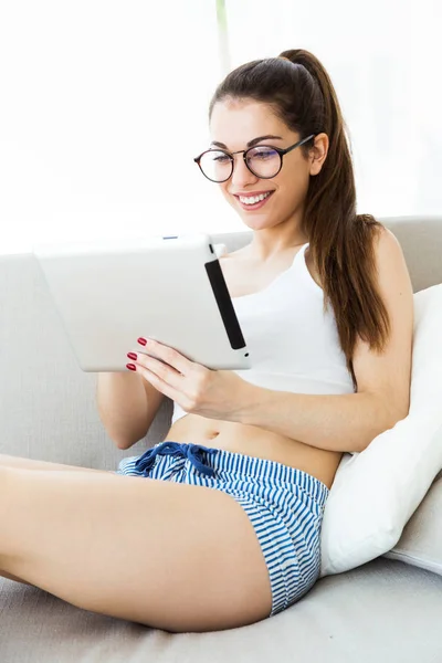 Mulher bonita usando seu tablet digital em casa . — Fotografia de Stock