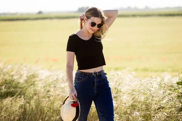 Mooie jonge vrouw genieten van de zomer in een veld. — Stockfoto