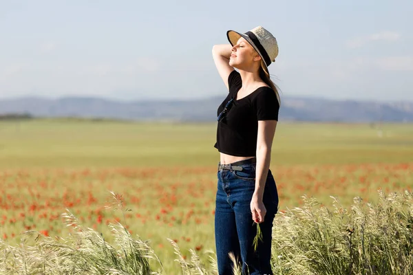 Schöne junge Frau genießt den Sommer auf einem Feld. — Stockfoto