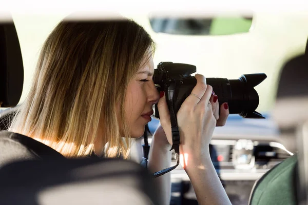 Beautiful young woman taking photos from the car. — Stock Photo, Image