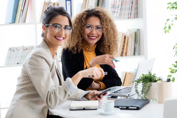 Deux femmes d'affaires travaillant avec un ordinateur portable dans son bureau . — Photo