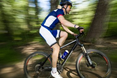 Yakışıklı genç adam dağın içinde Bisiklete binme.