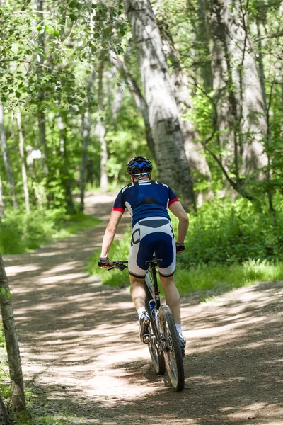 Bello giovane in bicicletta in montagna . — Foto Stock