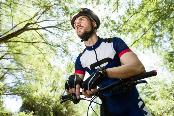 Handsome young man relaxing after cycling in the mountain. — Stock Photo, Image