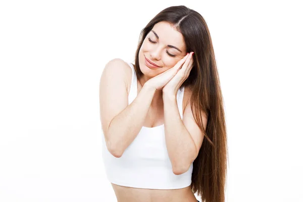 Hermosa mujer joven haciendo el gesto de dormir sobre fondo blanco . — Foto de Stock