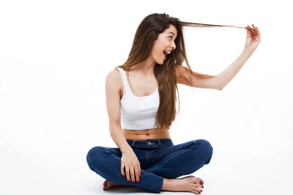 Hermosa mujer joven divirtiéndose sobre fondo blanco . — Foto de Stock