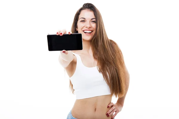 Hermosa mujer joven sosteniendo la pantalla en blanco teléfono móvil sobre fondo blanco . — Foto de Stock