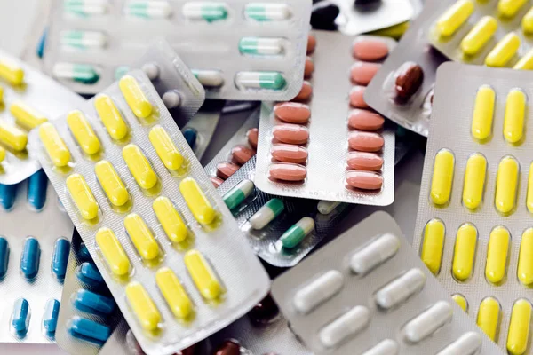 Comprimidos, comprimidos e cápsulas de medicamentos variados sobre a mesa . — Fotografia de Stock